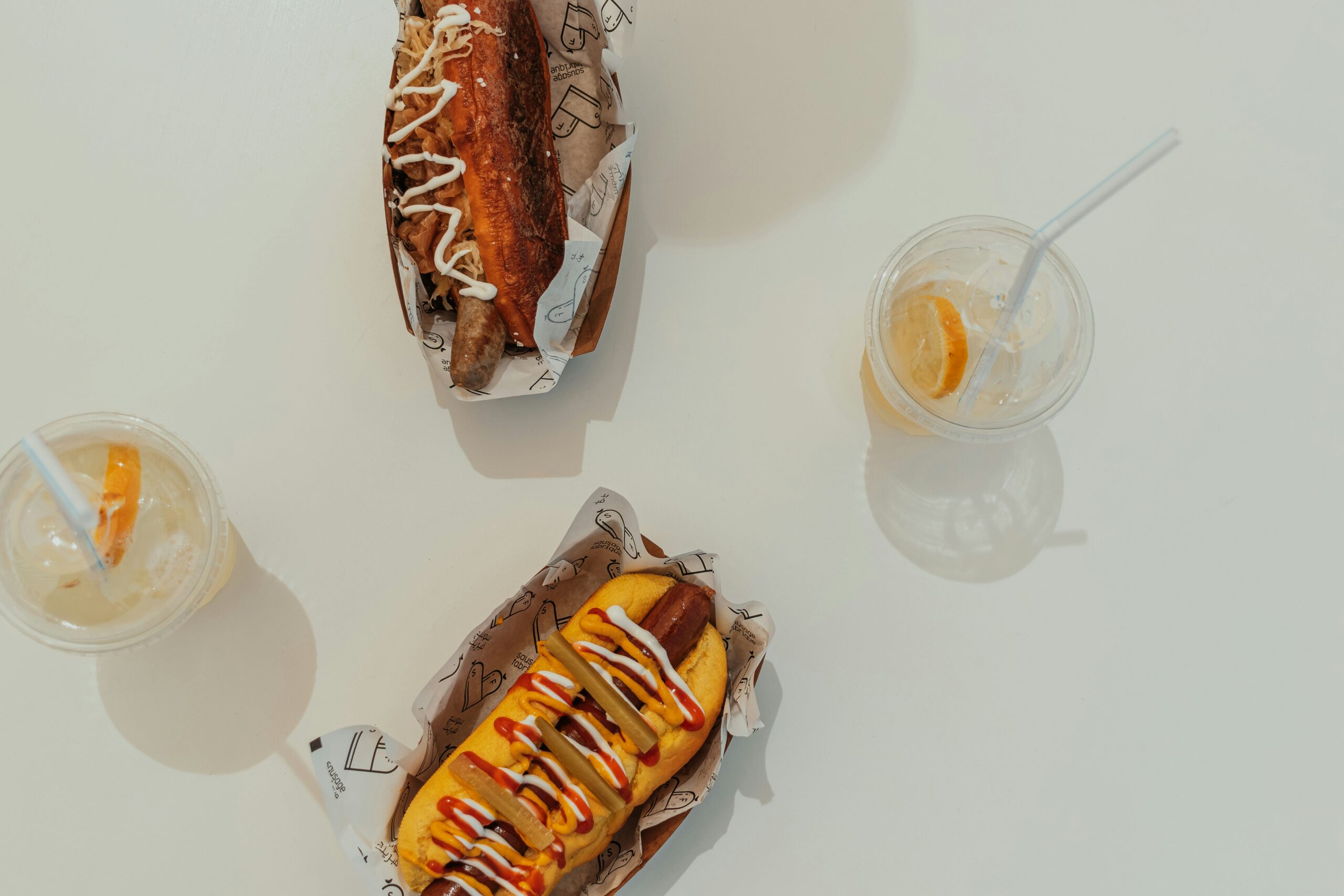 Two hotdogs and two drinks on a table